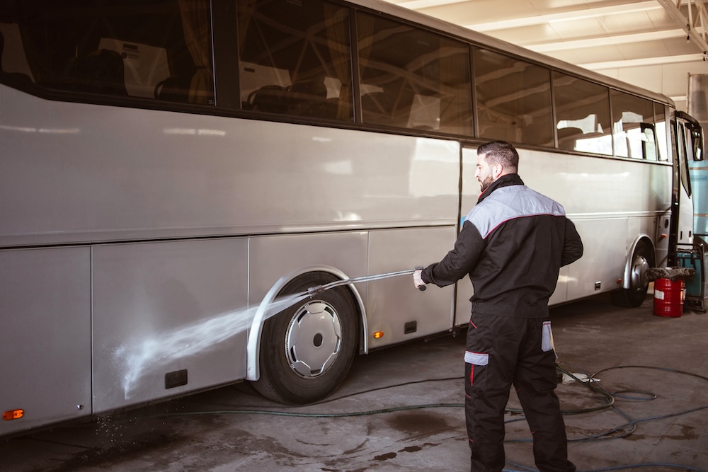 Professional worker washes a bus