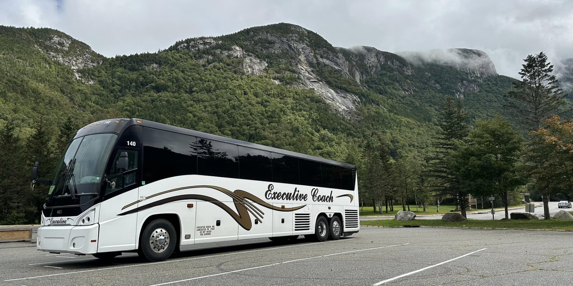 Coach bus driving near a mountain