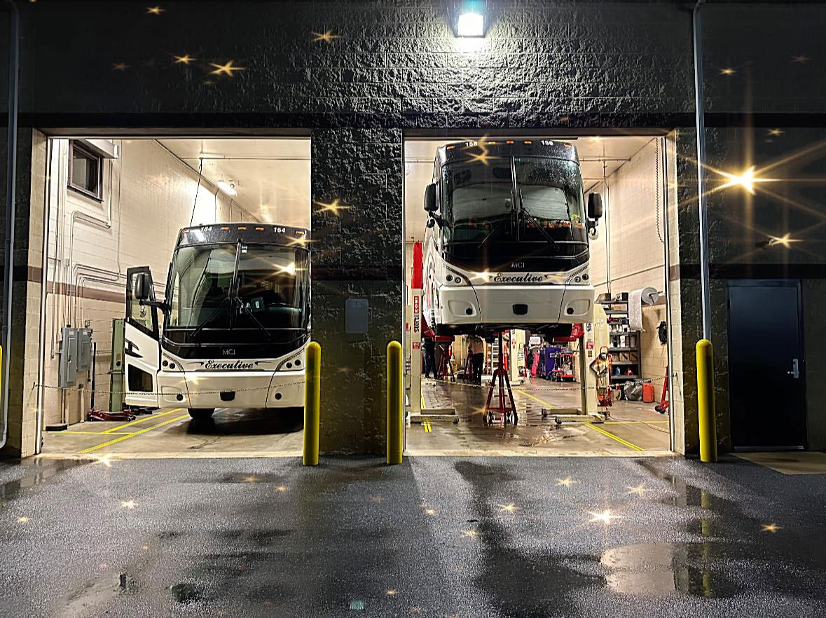 2 Executive Coach buses in the show getting maintenance done.