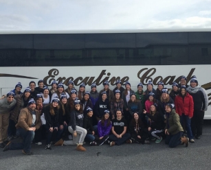 Group of people in front of a coach bus